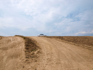 Пыльная грунтовая дорога привела автомобиль на вершину холма на мысе Меганом в Крыму