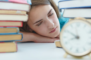 Sleepy brunette girl resting during education after sleepless night. Student in despair caused by exam deadline concept.