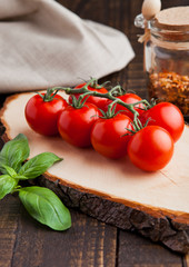 Fresh tomatoes with basil and spices jar on grunge board