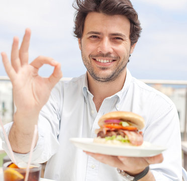 Young Man Eating A Hamburguer