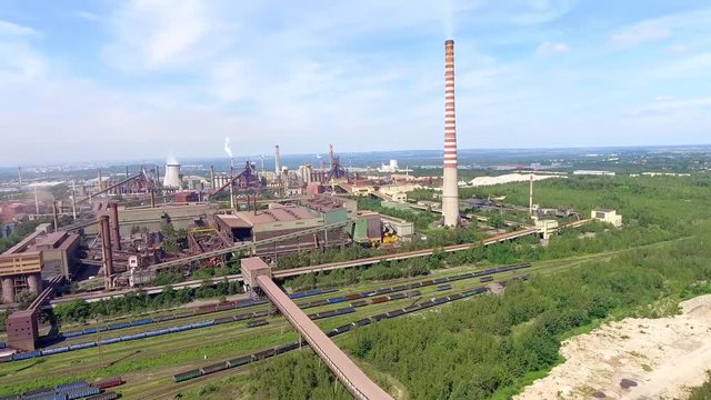 Steel factory with smokestacks at suny day.Metallurgical plant. steelworks, iron works. Heavy industry in Europe.Air pollution from smokestacks, ecology problems. Industrial landscape.View from above.