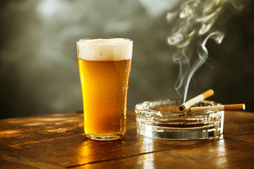 Schuimend ijskoud biertje en sigaret in een pub