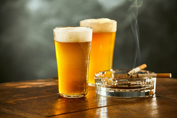 Deux bières fraîches avec des cigarettes allumées