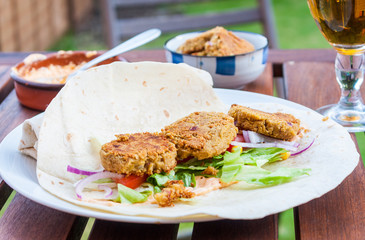 Open falafel wrap outside on a table