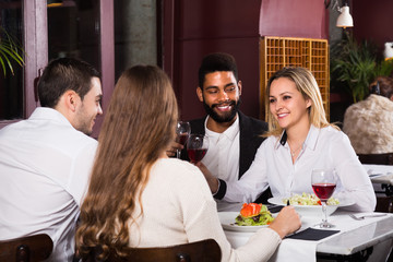 Group of friends eating at restaurant.