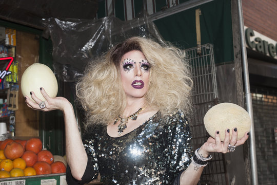 Drag queen holding two melons on the street