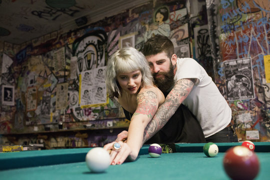 Young couple playing pool
