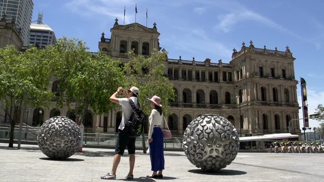 Asian tourists taking a photo by the Steam Sculpture by Donna Marcus in Reddacliff Place brisbane