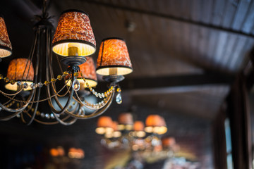 Chandelier in focus. Beautiful brand new european restaurant on the background.