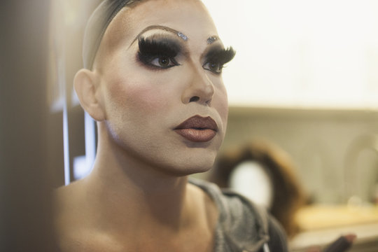 Performer checks dramatic makeup in mirror