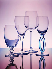Four empty transparent wine glasses composition
