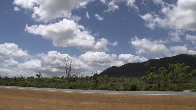 Pan from the road with cars passing by  through the Stirling Ranges