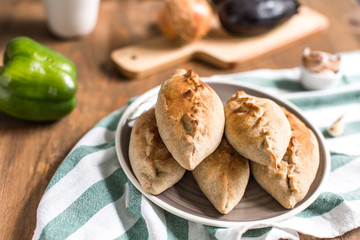 Hot pies with mushrooms on plate, vegetable calzone