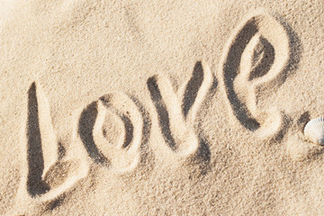 Love, word - written by hand in sand on a sea beach