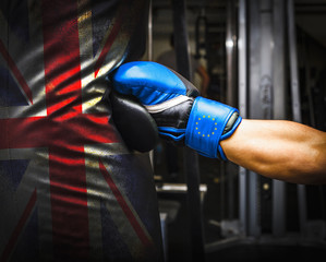Brexit. Blue punching gloves with yellow europe stars punching into a British punching bag.