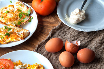 Scrambled, fried, boiled eggs on a wooden table