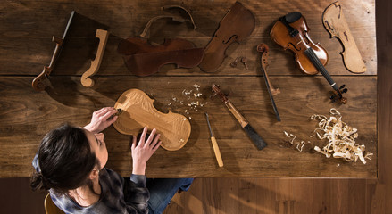 Top view. female luthier working on the creation of a violin