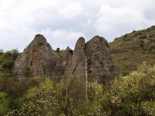 Вдоль дороги в крымских горах встречаются каменные глыбы причудливой формы