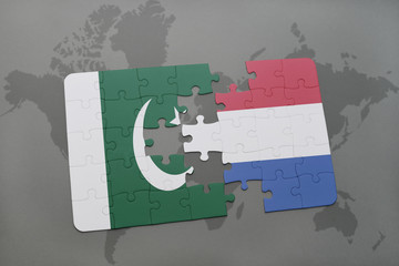 puzzle with the national flag of pakistan and netherlands on a world map background.