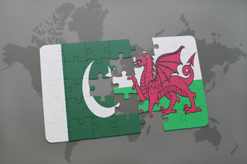 puzzle with the national flag of pakistan and wales on a world map background.