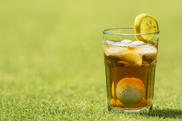 Parody of iced tea in a glass combined with a golf ball and tee