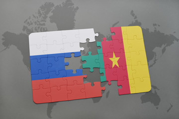 puzzle with the national flag of russia and cameroon on a world map background.