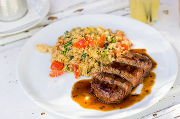 Beef stake with rice, vegetables, lemon juice and olive oil