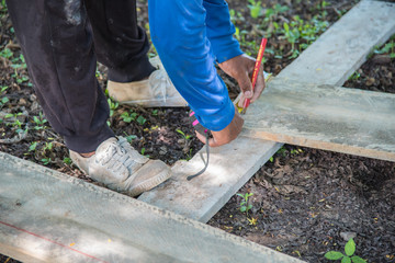 Worker measuring stainless steel railing with measuring tape in construction site