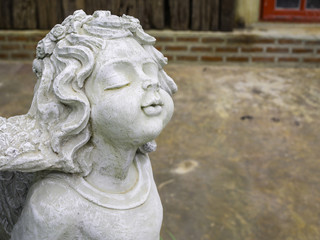 Naklejka premium Cherub sculpture closing eyes and kissing