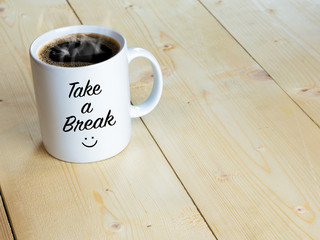 Take a break with smiley face on mug or coffee cup on wood table