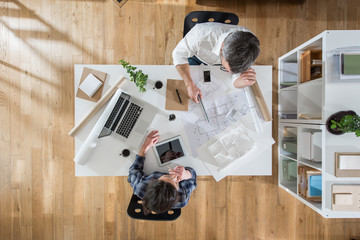 Top view at office. Two architects working on a project