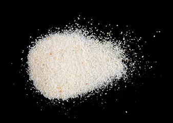 Pile of sand isolated on black background