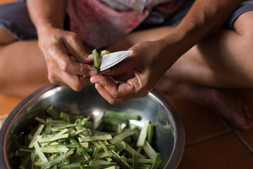 Ask a hand holding a knife and peeled horseradish.