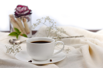 coffee in bed. cup of coffee with spices cloves on a white blanket