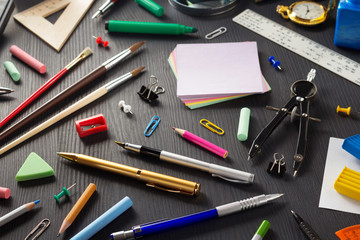 school supplies on black wood