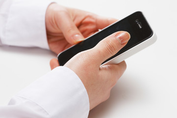 スマートフォンを持つ女性の手 