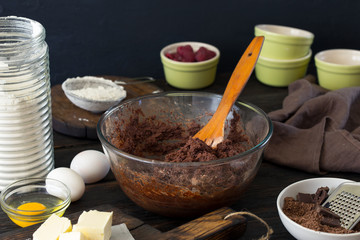Food ingredients for cooking chocolate dessert on dark wooden ta
