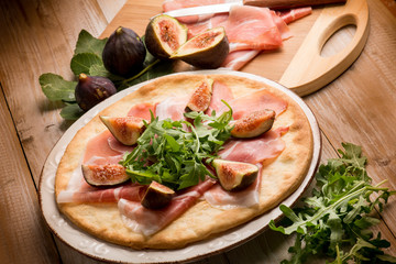 pizza with figs parmesan ham and arugula