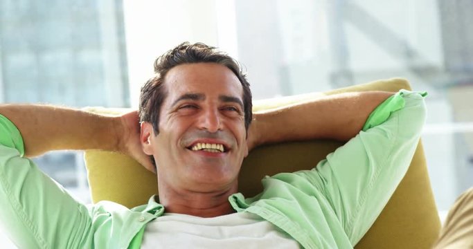 Smiling man relaxing on sofa at home