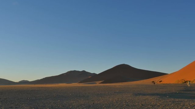 famous  namibian icon sossusvlei desert landscape from high position panning sun rays backlit uhd 4k
