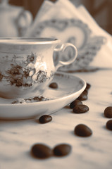 Vintage cup of coffee and coffee beans on the table