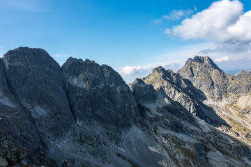 Obraz premium Amazing rocky mountain ridge under blue sky with white clouds