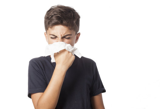 child blowing the nose has a cold