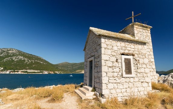 Small church on the rock, sea in the background