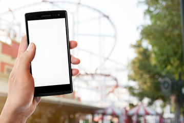 Hand holding smart phone on blurred park, natural background