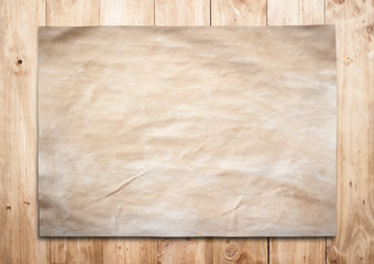 Old paper on a brown wooden surface.