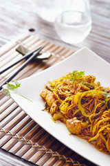 sweet chili noodles in a white serving plate with chopsticks, bright colors, modern style