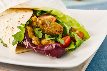 pork wraps on a white serving plate with rocket and lettuce, pastel colors