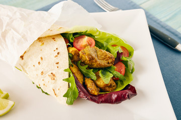 pork wraps on a white serving plate with rocket and lettuce, pastel colors