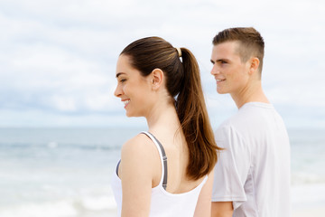 Fototapeta premium Young couple looking thoughtful while standing next to each other on beach